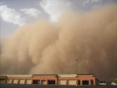 A large amount of dust particles is released from the land surface and blown upward by turbulent wind. 